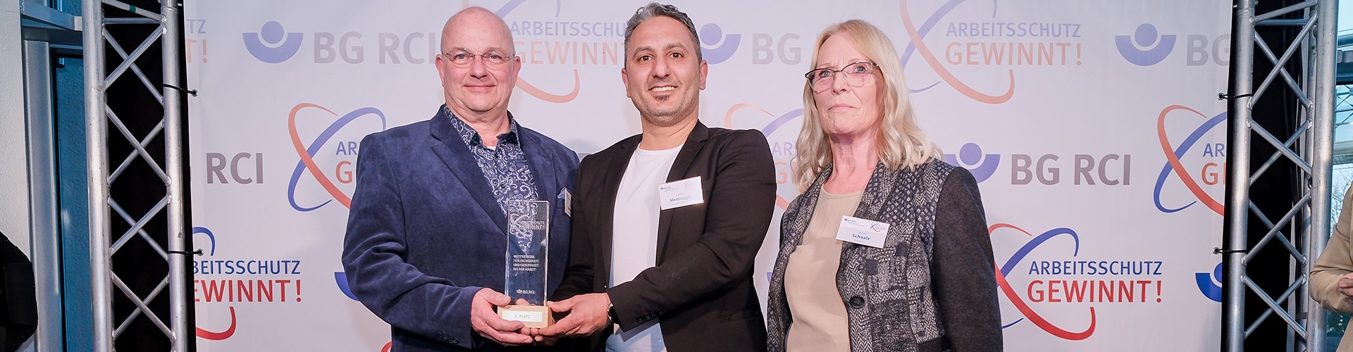 (v. l.): Rainer Rehkopp und Levent Memisoglu (RAG Aktiengesellschaft, 3. Platz) mit Gabriele Schaale, Vorsitzende Beirat Lederindustrie, BG RCI